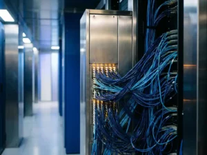 Lichtgevende glasvezelkabels convergeren naar een serverrack in een datacentergang met kobaltblauwe en zilveren tinten.